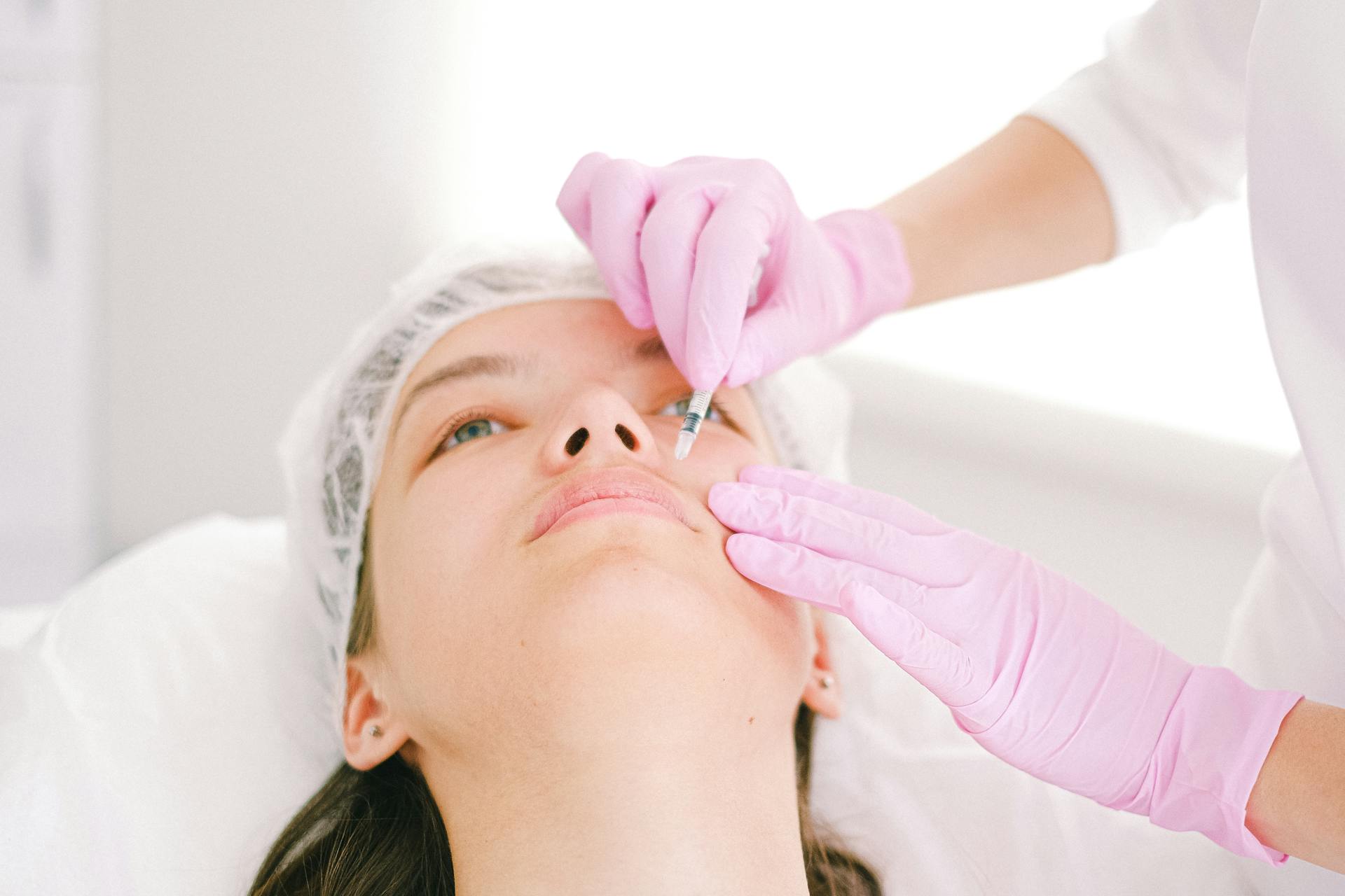 A close-up of a woman undergoing a non-invasive cosmetic filler procedure