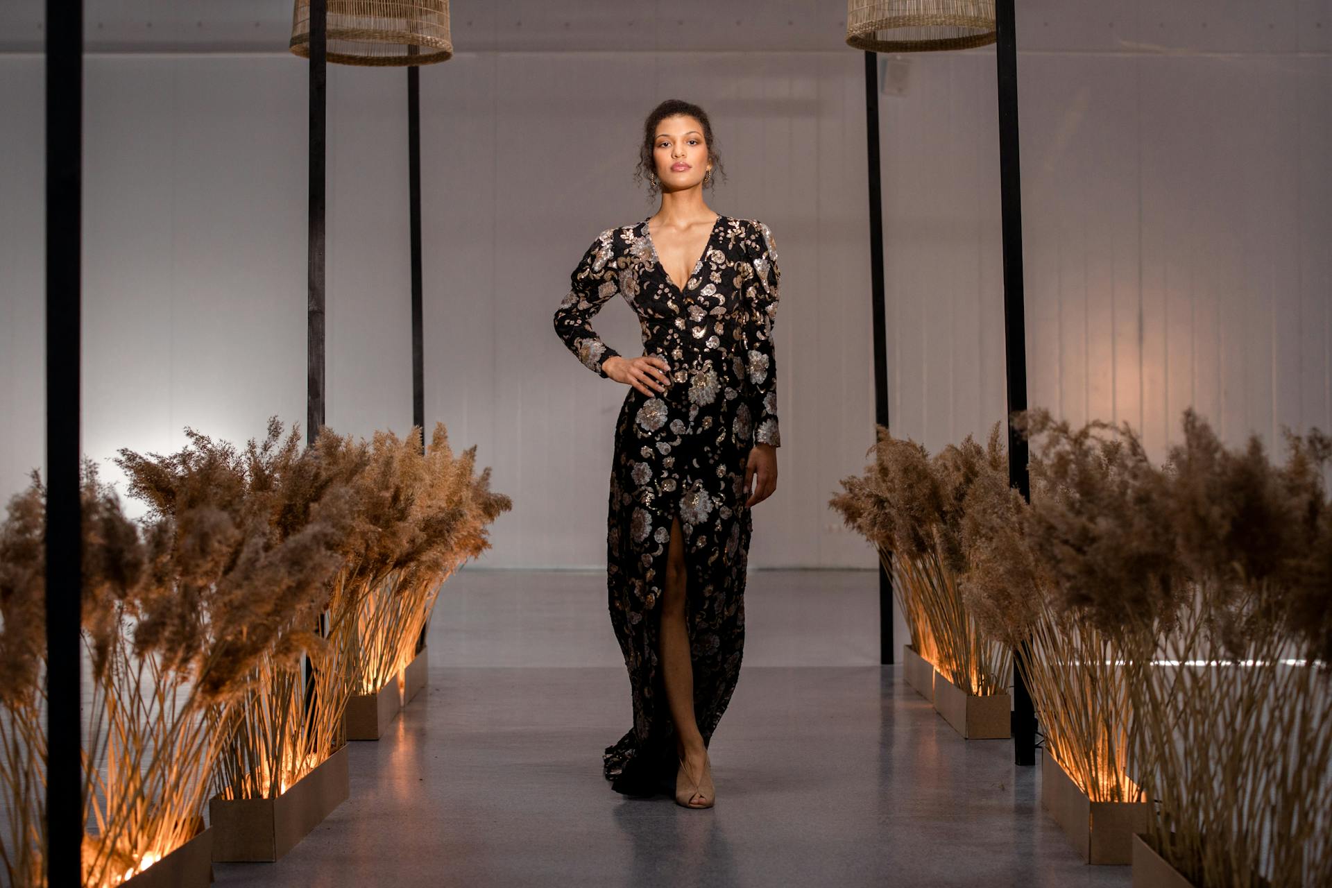 A model walking on a runway in a black floral couture dress, embodying modern couture trends